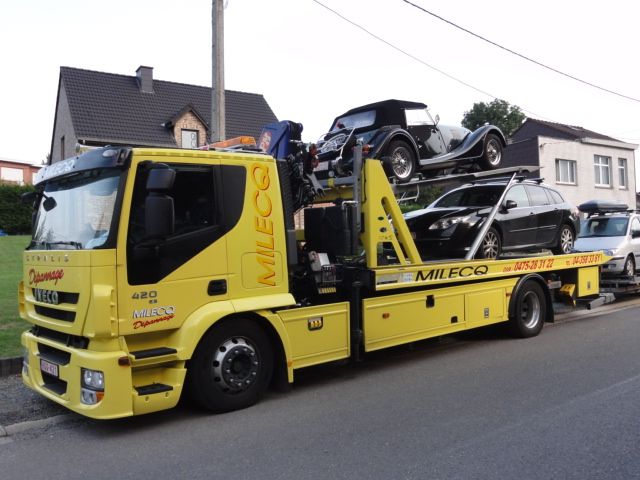 Voiture ancêtre décapotable sanglée sur le plateau du camion Milecq